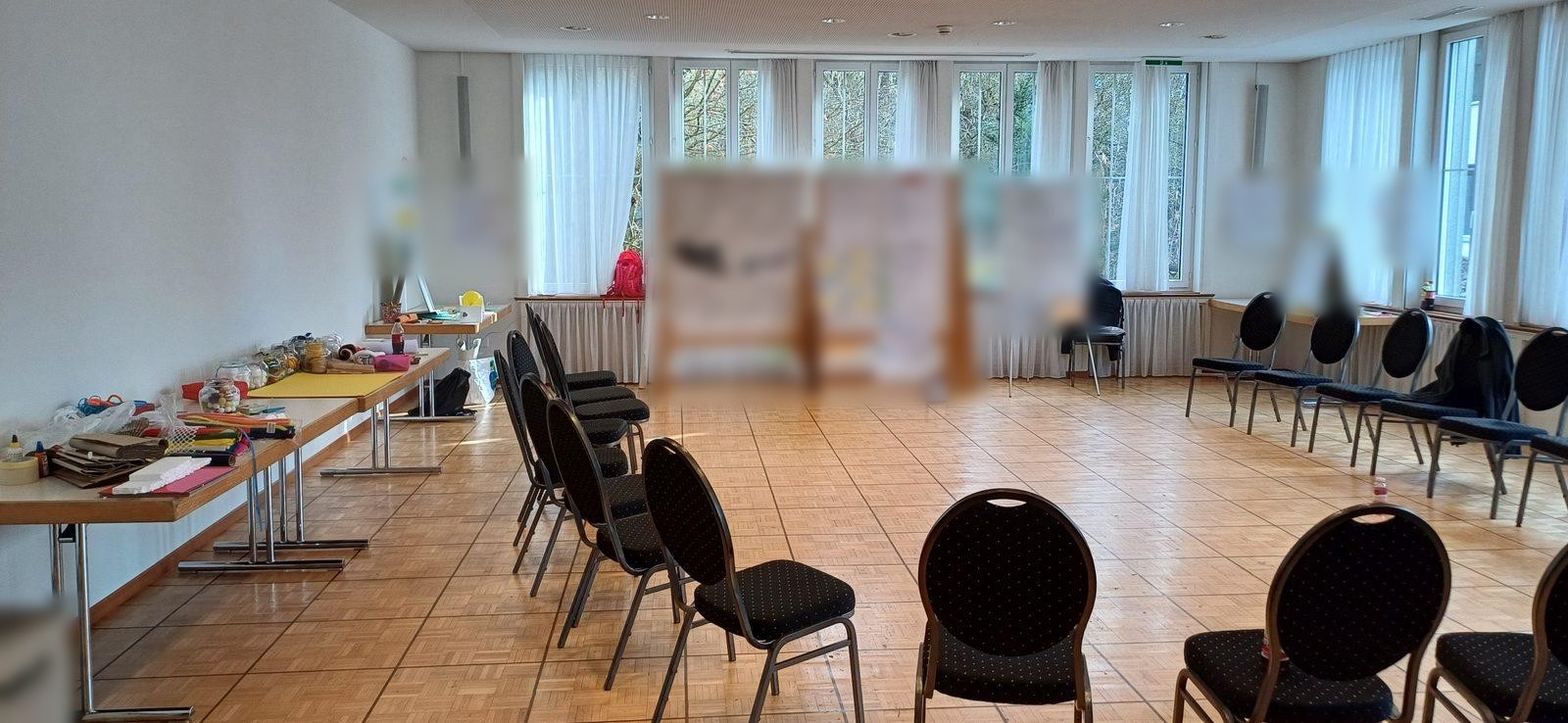 Workshop-Raum mit Flipcharts, Material und Arbeitstischen